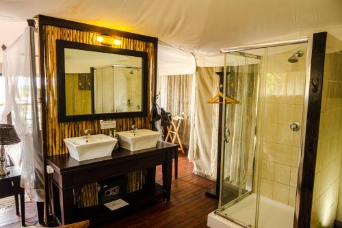 a bathroom with two sinks and a shower at Taranga Safari Lodge in Rundu
