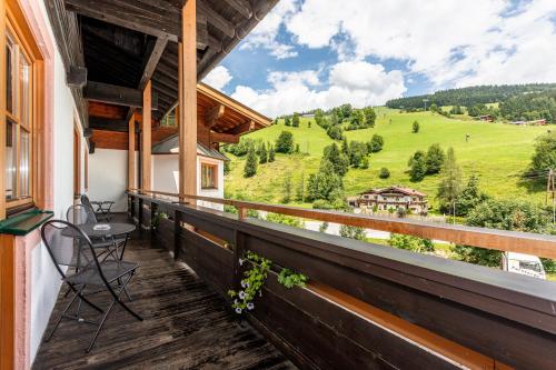 a balcony with a view of a green field at Hotel Unser Unterberg in Maria Alm am Steinernen Meer