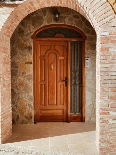 an archway with a wooden door in a brick building at Casa Cardona in Móra d'Ebre