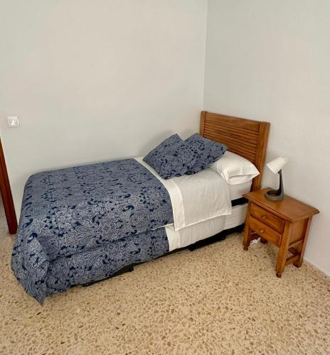 um quarto com uma cama e uma mesa com um candeeiro em HABITACIÓN DOBLE (DOS CAMAS) EN CENTRO HISTÓRICO em Cartagena