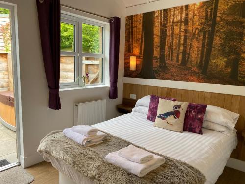 1 dormitorio con 1 cama con toallas en Badger Lodge with Hot Tub, en Cupar