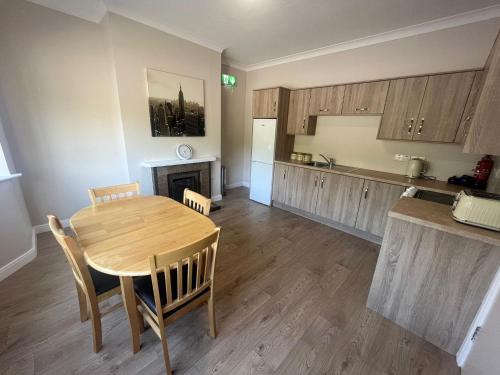 cocina y comedor con mesa y sillas en Yeats Lodge Self catering Apartment and Bar, en Galway