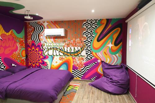 a room with two beds and a colorful wall at Capsule Groovy-Jacuzzi-Sauna-Billard-Netflix- Nintendo Switch & Jeux in Mons