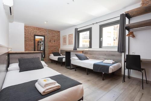 a room with three beds and two windows at HOSTAL BEDMATES in Barcelona