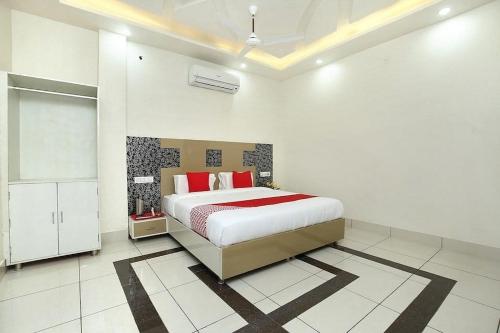 a bedroom with a bed with red pillows on it at LUCKY HOTEL AND RESTAURANT in Kurukshetra