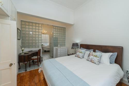 a bedroom with a bed and a desk and a bathroom at 60 on Montagu in Mossel Bay