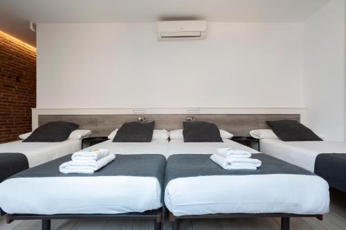 a room with four beds with towels on them at HOSTAL BEDMATES in Barcelona
