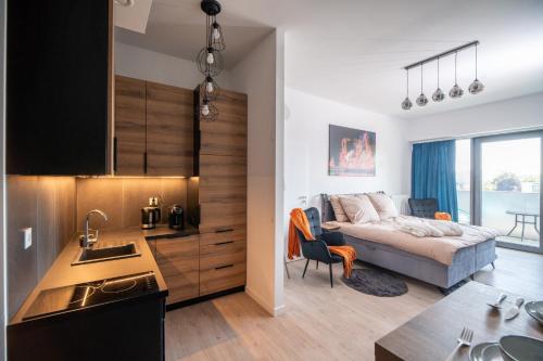 a kitchen and a bedroom with a bed in a room at Hanza Tower Luxury in Szczecin