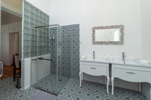 a bathroom with a shower and two sinks and a mirror at 60 on Montagu in Mossel Bay