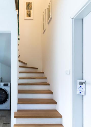 a staircase in a house with white walls and wooden floors at Beautiful and private Villa Anka in Lokvičič