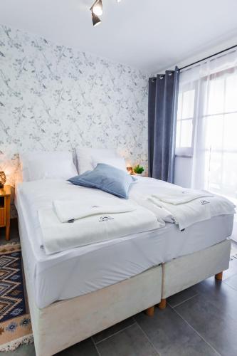 a bedroom with a large bed with white sheets at Panorama Górska Wisła Resort & SPA in Wisła