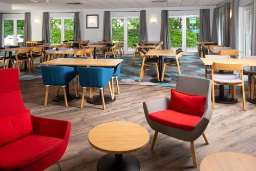 een eetkamer met tafels en stoelen en een eettafel bij Holiday Inn Express Peterborough, an IHG Hotel in Peterborough