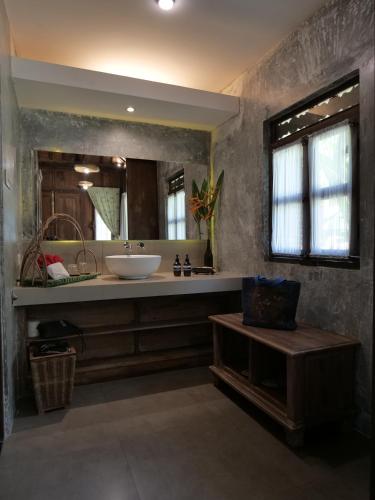 a bathroom with a sink and a large mirror at Amata Borobudur Resort in Borobudur