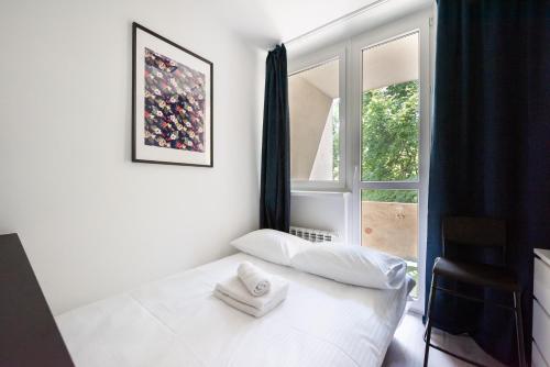 a bedroom with a white bed and a window at Wola Comfort Studio #1 in Warsaw