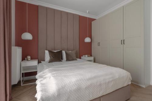 a bedroom with a white bed and red walls at APARTIO ROOMS Gliwice in Gliwice