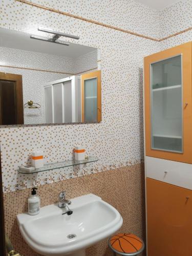 La salle de bains est pourvue d'un lavabo et d'un miroir. dans l'établissement Vivienda Turística LA TRINIDAD, à Úbeda