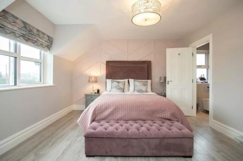 um quarto com uma cama grande e uma colcha rosa em Louth Village Wedding Accommodation with Gym B&B em Lubhaidh