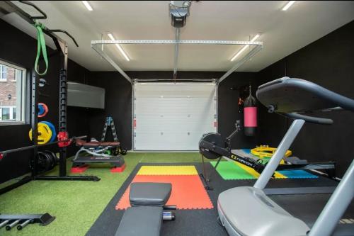 un gimnasio con cinta de correr y otros equipos en una habitación en Louth Village Wedding Accommodation with Gym B&B, en Lubhaidh