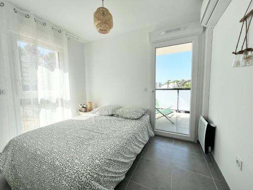 une chambre blanche avec un lit et une fenêtre dans l'établissement Joli appartement neuf La Ciotat, à La Ciotat
