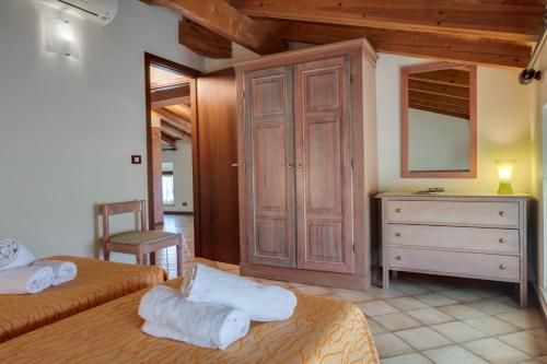 a bedroom with two beds and a dresser with a mirror at Residence La Filanda in Costermano