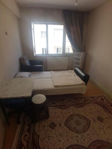 a small bedroom with a bed and a window at Student and youth hostel in Sivas