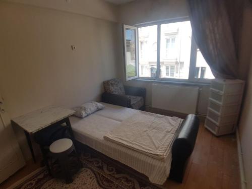 a bedroom with a bed and a table and a window at Student and youth hostel in Sivas