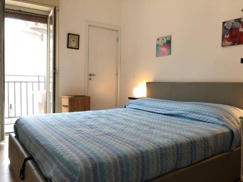 a bedroom with a bed with a blue plaid blanket at La Masa Apartment in Palermo