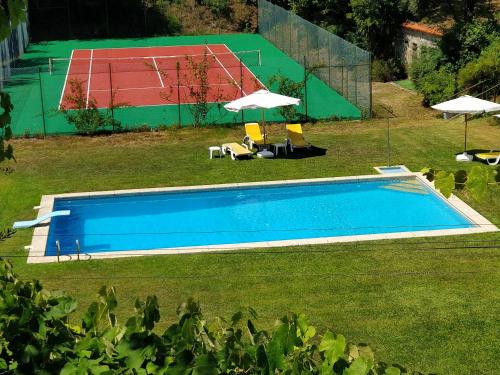 an overhead view of a swimming pool with two umbrellas at Quinta de São Simão Turismo e Eventos in Vieira do Minho