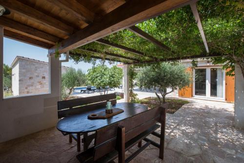 a wooden table and benches on a patio at Luxury Villa Nature with heated private pool, sauna & fire pit, a short walk to the beach in Milna