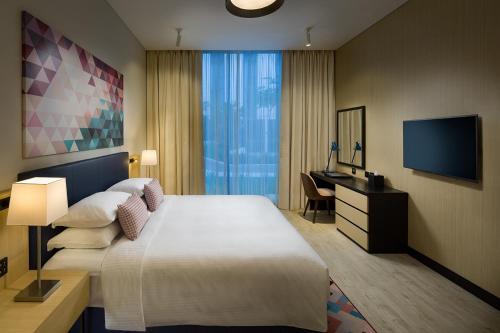 a hotel room with a bed and a desk and a television at SILVER FOX HOMES in Dubai