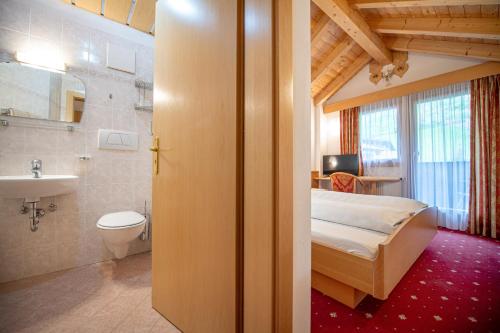 a bedroom with a bed and a sink and a toilet at Apartments Culac in Santa Cristina Gherdëina
