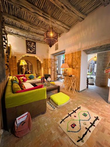 a living room with a green couch and a table at Les Terrasses d'Essaouira - Yoga Studio in Essaouira