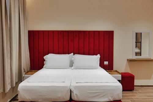 ein Schlafzimmer mit einem großen Bett mit rotem Kopfteil in der Unterkunft Armar Hotel in Sarandë