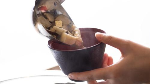 a person holding a cup of food with a spoon at Onyado Nono Asakusa Natural Hot Spring in Tokyo