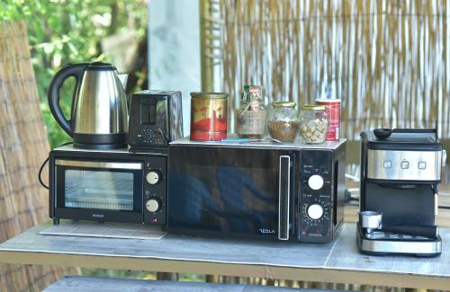 um micro-ondas e comodidades para preparar café numa mesa em Вили Водно Конче Villas Vodno Konche em Ahtopol