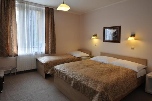 a hotel room with two beds and a window at Hotel Wilhelm in Prague