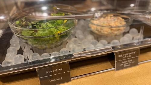 a display case with a bowl of lettuce and other food at Onyado Nono Asakusa Natural Hot Spring in Tokyo