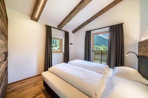 1 dormitorio con 2 camas y ventana en Chalet zu Wosser en San Leonardo in Passiria