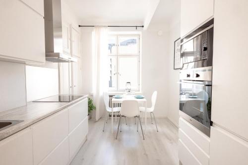 ヘルシンキにある2ndhomes Lapinlahdenkatu Apartmentの白いキッチン(テーブル、椅子付)