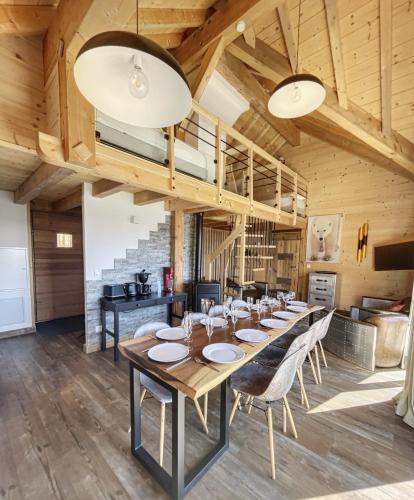 a large dining room with a long table and chairs at Chalet L'Albaron in La Toussuire