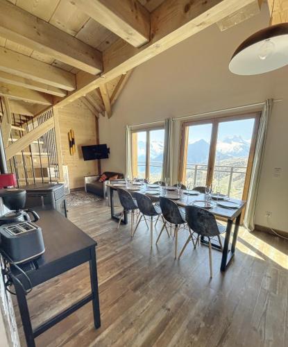 Cette grande chambre comprend une grande table et des chaises. dans l'établissement Chalet L'Albaron, à La Toussuire