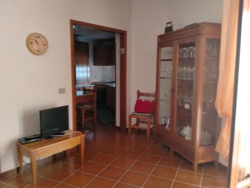 uma sala de estar com televisão e um armário em Casa Rosa em Cirò