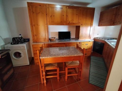uma cozinha com armários de madeira e uma mesa com cadeiras em Casa Rosa em Cirò