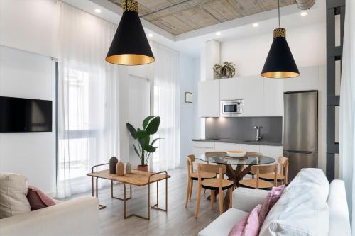 ein Wohnzimmer mit einer Couch und einem Tisch in der Unterkunft Suites Maestranza - Herrería by Magno Apartments in Sevilla