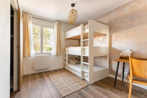 a room with bunk beds with a desk and a window at Appartement Maeva in Saint-Pée-sur-Nivelle