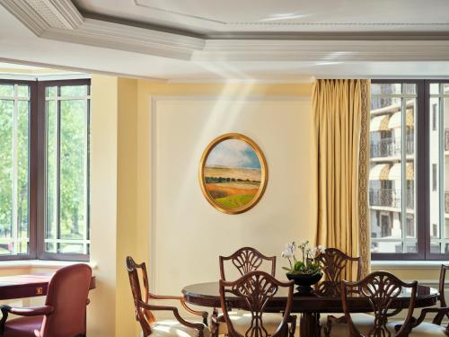a dining room with a table and chairs and windows at The Dorchester - Dorchester Collection in London