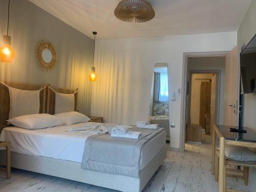 a bedroom with a white bed and a mirror at Litsa Apartments in Fourka