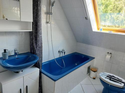 y baño con bañera azul y aseo. en Wruck,Ferienwohnung en Schneverdingen