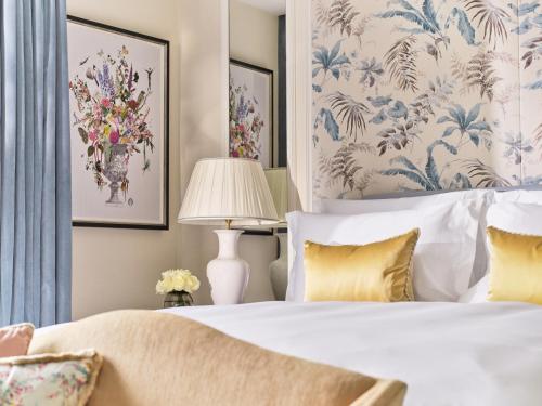 a bedroom with a bed with blue and white wallpaper at The Dorchester - Dorchester Collection in London