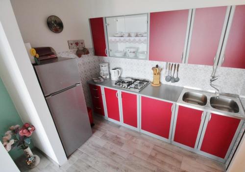 a kitchen with red and white cabinets and a refrigerator at Apartment Zeljka in Crveni Vrh